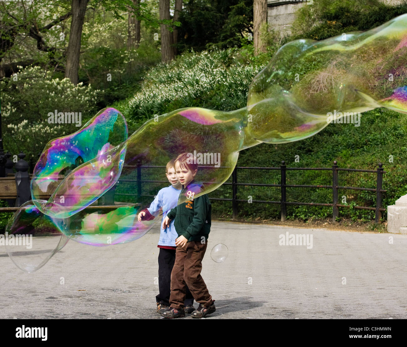 Two young boys staring in wonder at massive soap bubbles in Central Park in New York City. Stock Photo