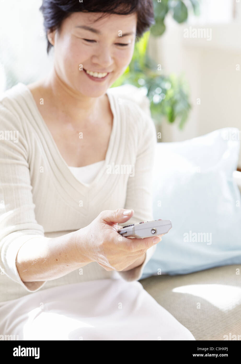 Senior woman using remote control Stock Photo - Alamy
