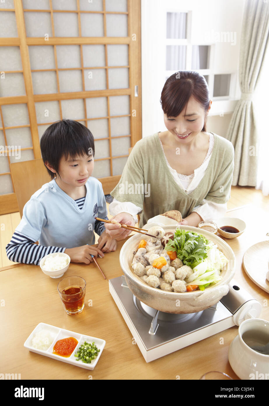 Mother and son sitting around Japanese hot pot Stock Photo - Alamy