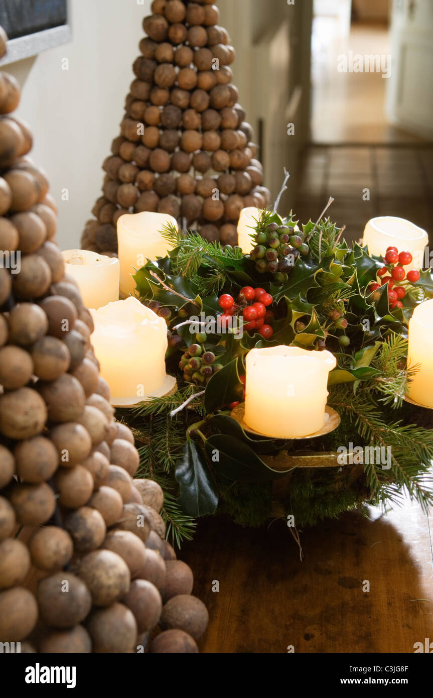 Festive candle decoration on table with nut pyramids Stock Photo