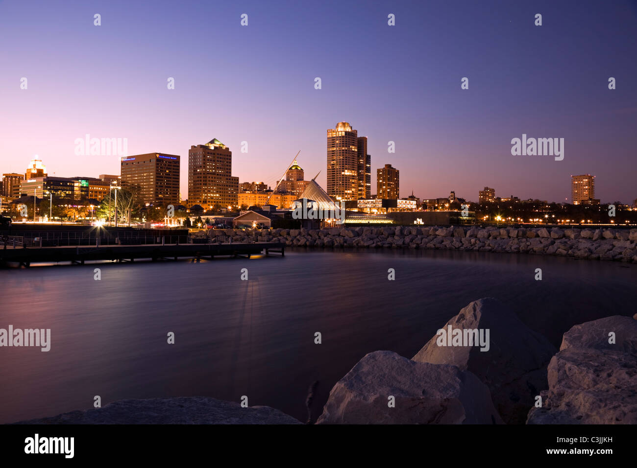 USA, Wisconsin, Milwaukee skyline across lake at dusk Stock Photo