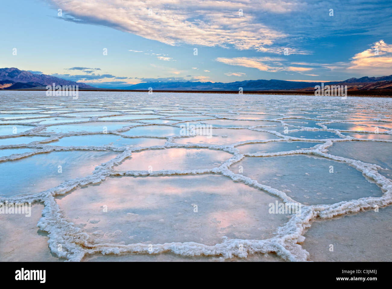 First light reveals rare rainfall in the reflecting salt polygons of Badwater Basin in