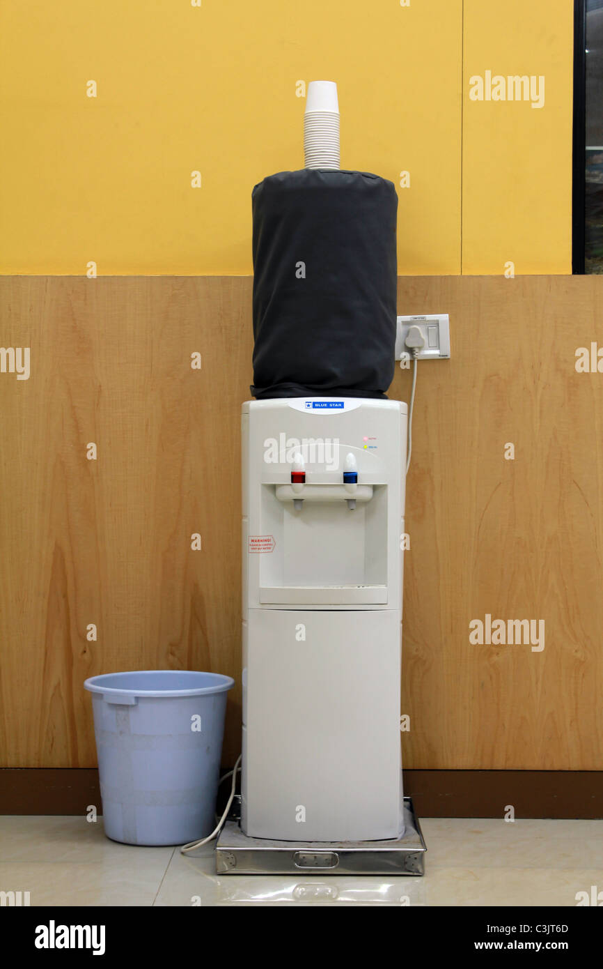 A water dispenser with a bin at the bottom Stock Photo