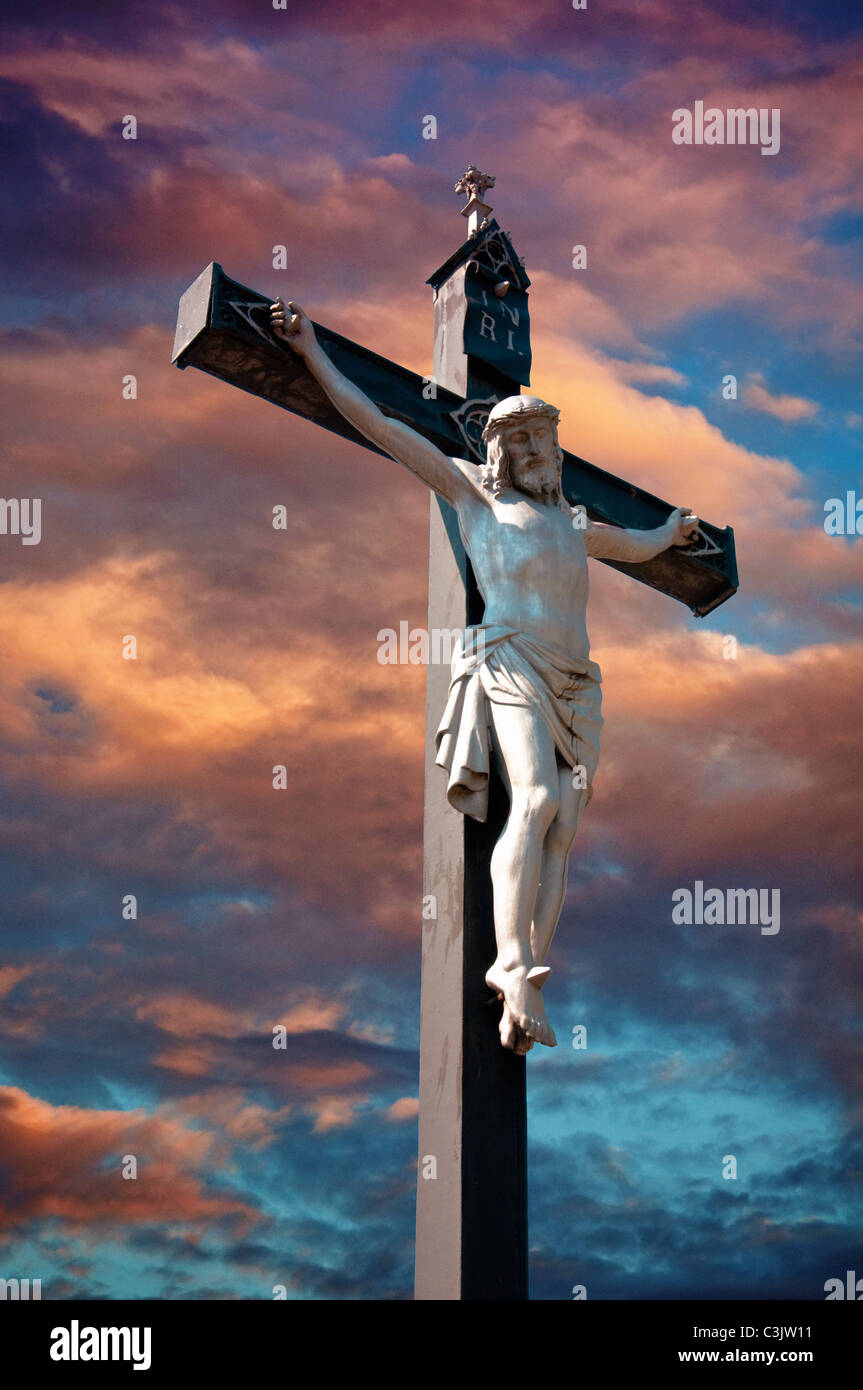 A statue of Jesus Christ crucified against dramatic sky Stock Photo - Alamy