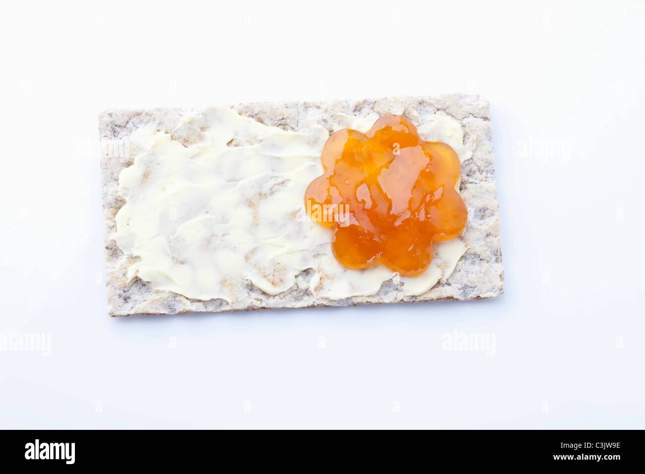Crispbread with butter and flower shaped apricot jam Stock Photo