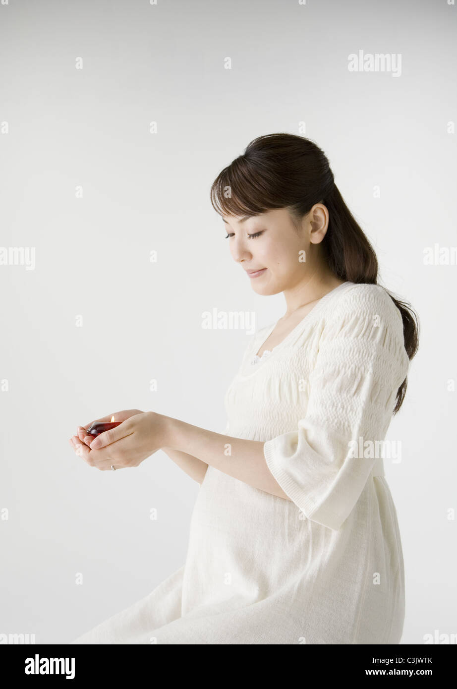 Pregnant woman holding candle Stock Photo Alamy