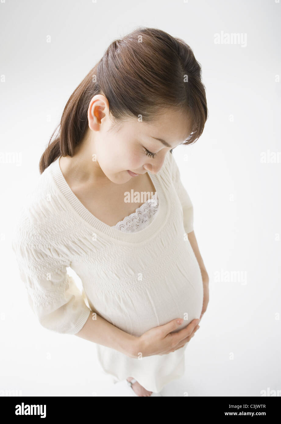 Pregnant woman holding belly Stock Photo