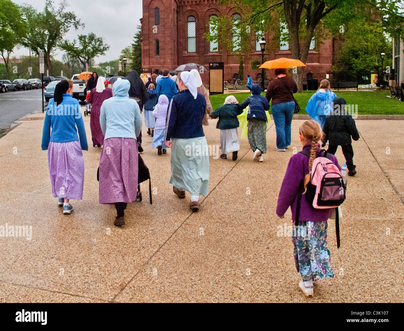 Mennonite tourists in their traditional 'Plain People' clothes visit the National Mall in Washington, DC., Smithsonian in rear. Stock Photo