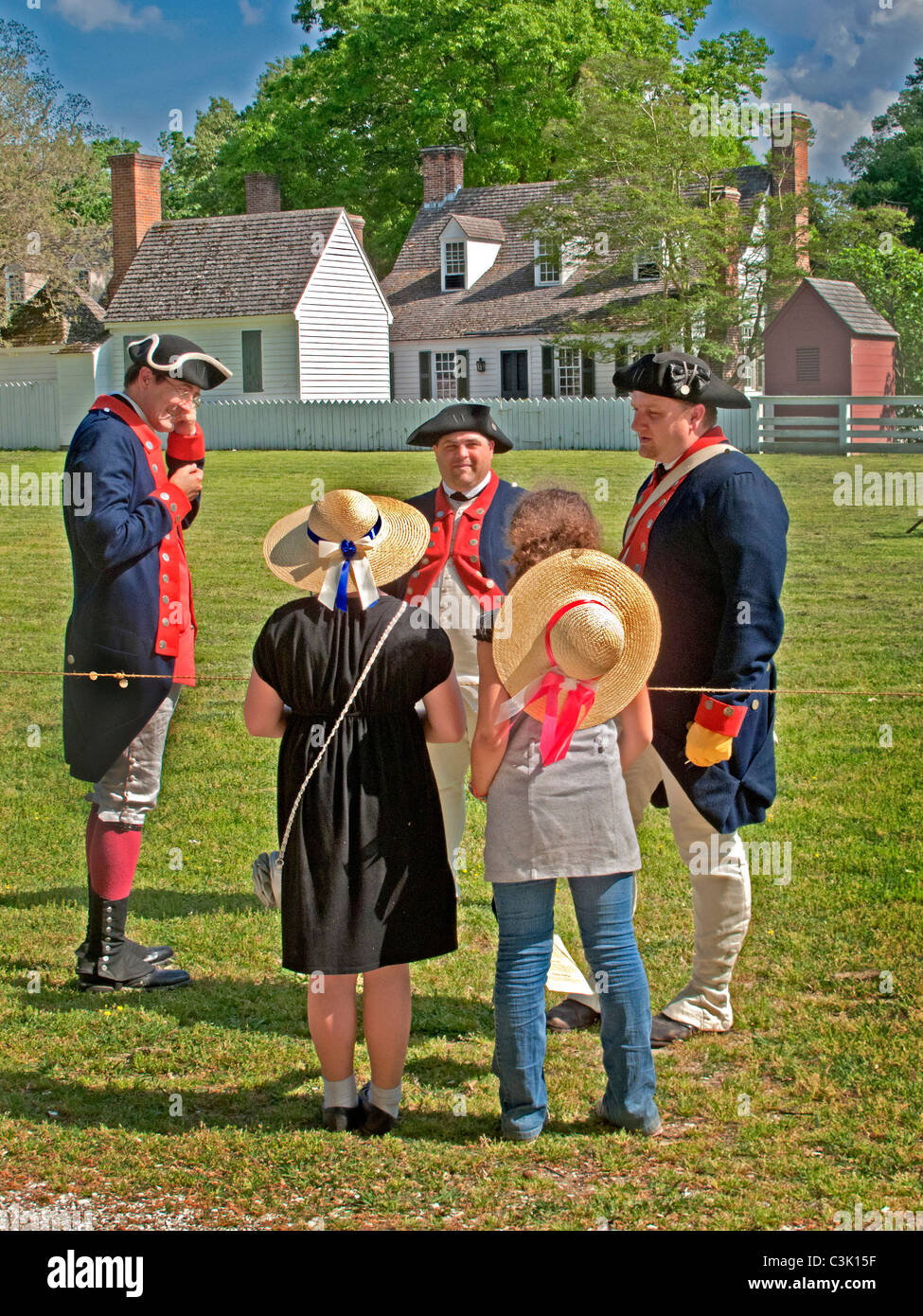Wearing historic uniforms, reenactors portraying soldiers talking with tourists in Colonial Williamsburg, VA. Stock Photo