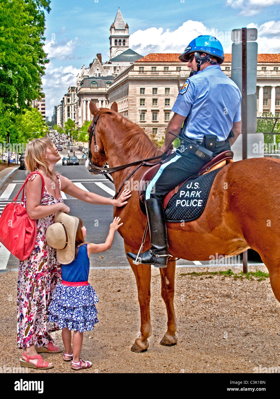 A mother and daughter talk to a U.S. Park Policeman while petting his horse on the National Mall in Washington, D.C. Stock Photo