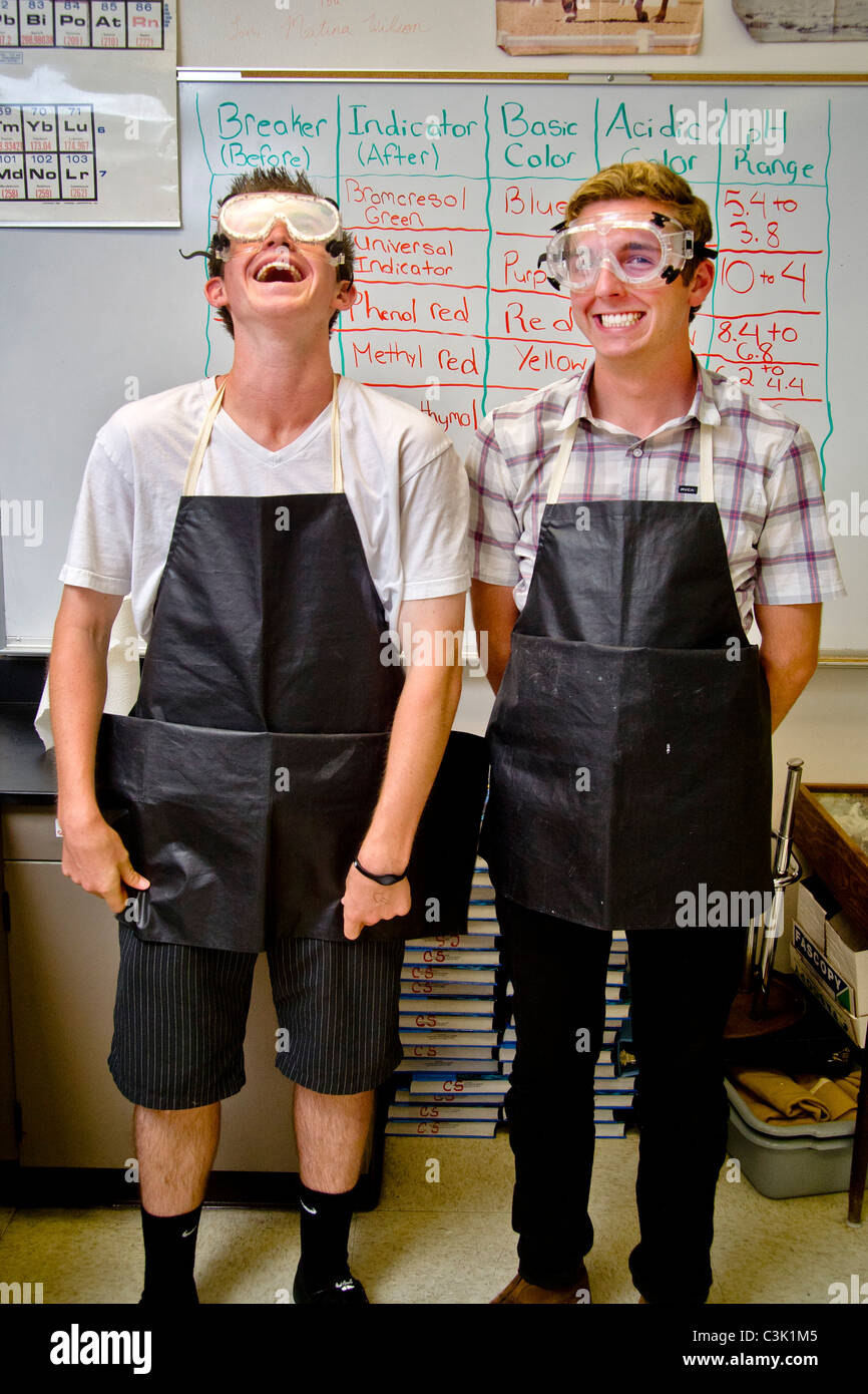 Two happy high school chemistry students in San Clemente, CA, are equipped for a laboratory experiment wearing safety goggles. Stock Photo