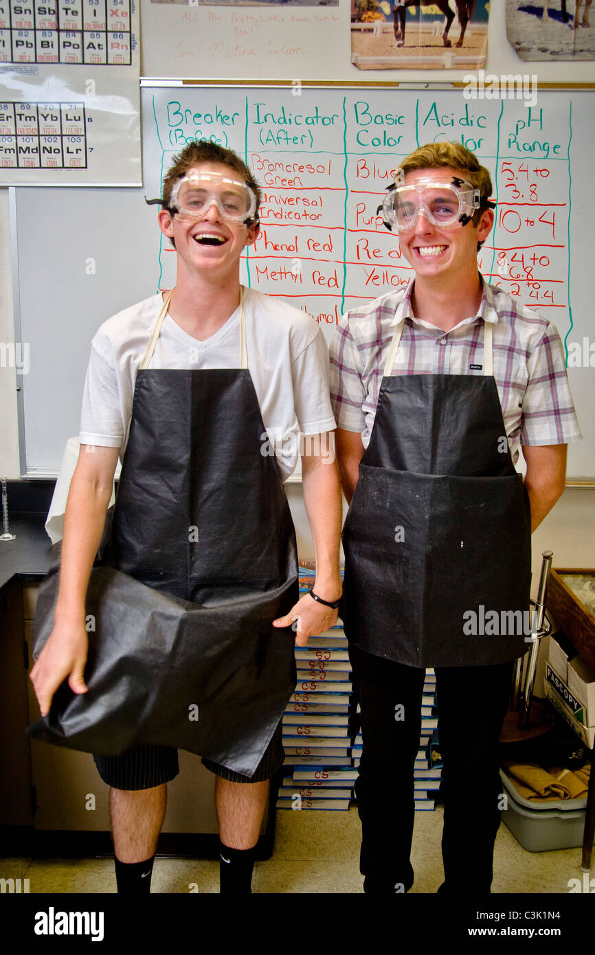 Two happy high school chemistry students in San Clemente, CA, are equipped for a laboratory experiment wearing safety goggles. Stock Photo