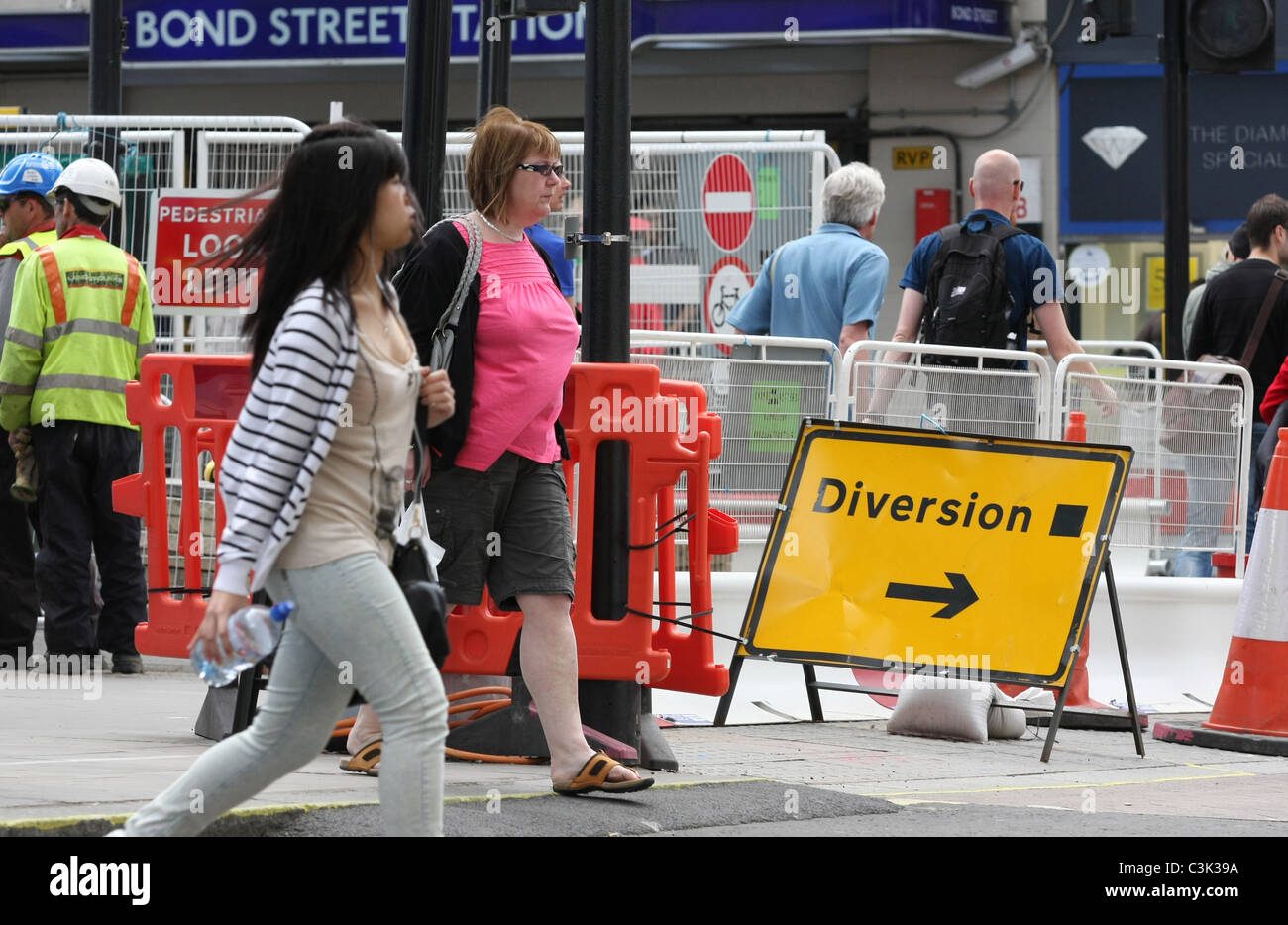 Two women passing a diversion sign in roadworks in Oxford Street, London, England Stock Photo