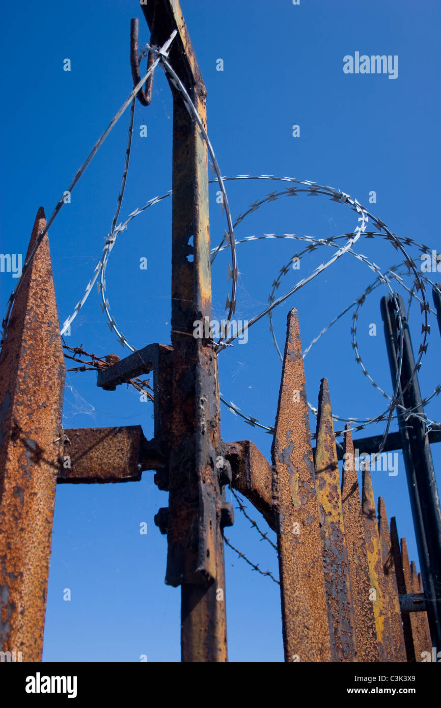 security fence rust spike top barb wire blue sky row keep out deterrent