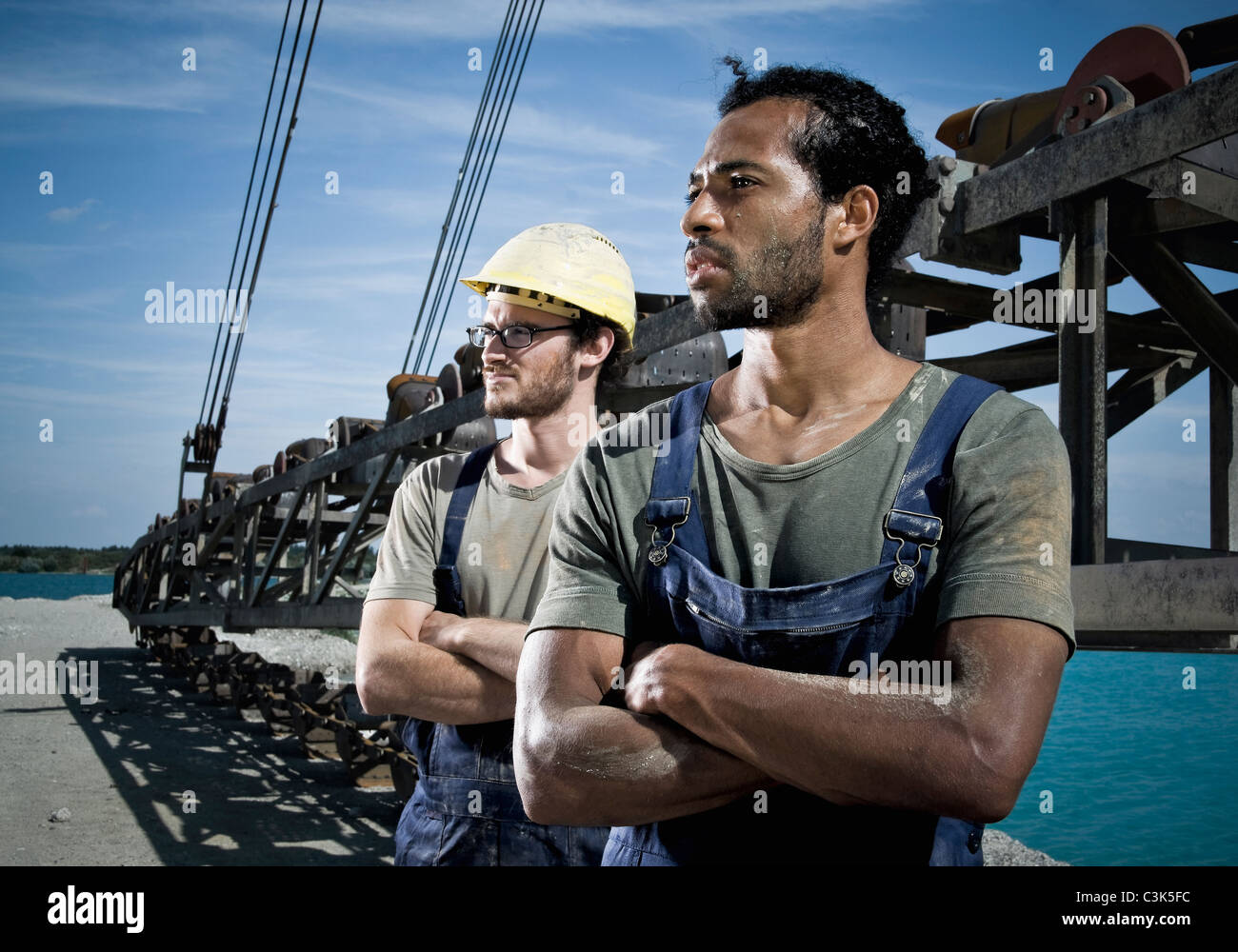 Germany, Augsburg, Two workers looking away with arms crossed Stock Photo