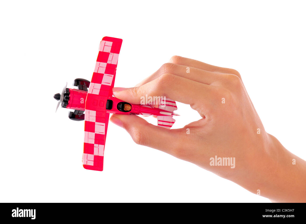 Macro shot of the hand of a kid holding a toy plane isolated on white Stock Photo