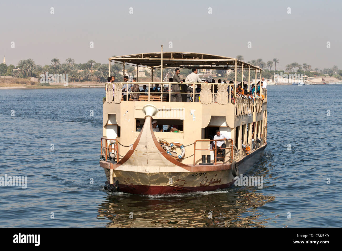 Luxor local ferry turning in the river for the East Bank palms in the background, Luxor, Egypt, Africa Stock Photo