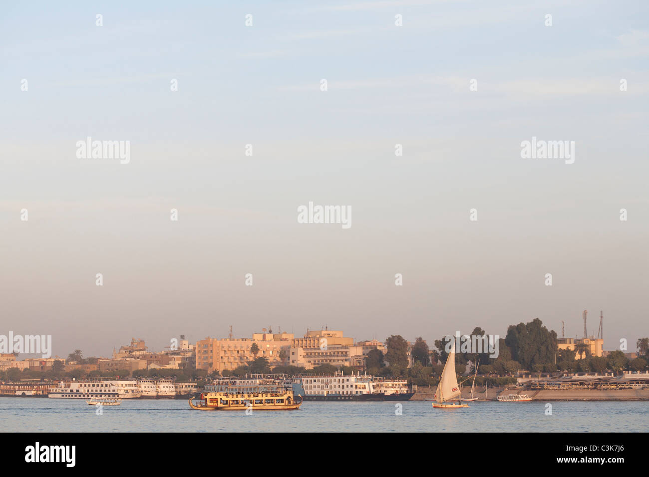 Felucca, local ferry and cruise boats sailing on the River Nile at sunset, Luxor, Egypt, North Africa Stock Photo