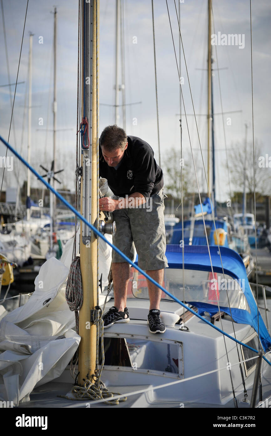 Man adjusting rigging on a sail boat Stock Photo Alamy