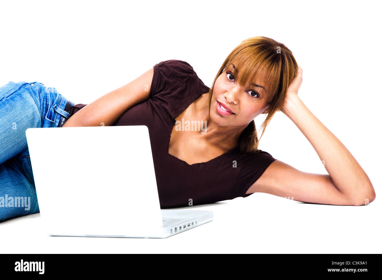 Woman lying on the floor and working on a laptop isolated over white ...