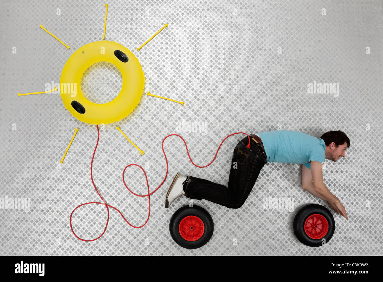 Mid adult man forming car shape connected to sun shape float Stock Photo