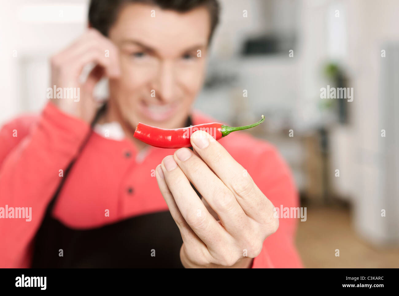 Germany, Cologne, Man holding red chilli Stock Photo - Alamy
