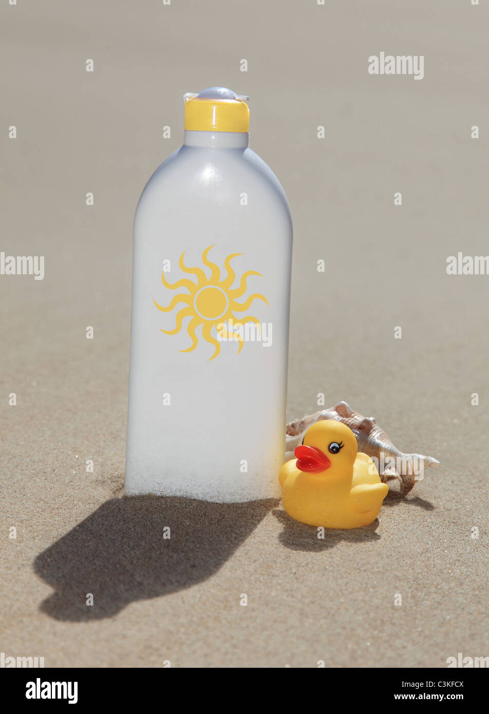 A bottle with suntan lotion standing in the sand. Stock Photo
