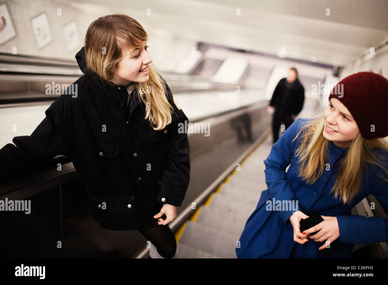 Two teenage girls (14-15) on escalator Stock Photo