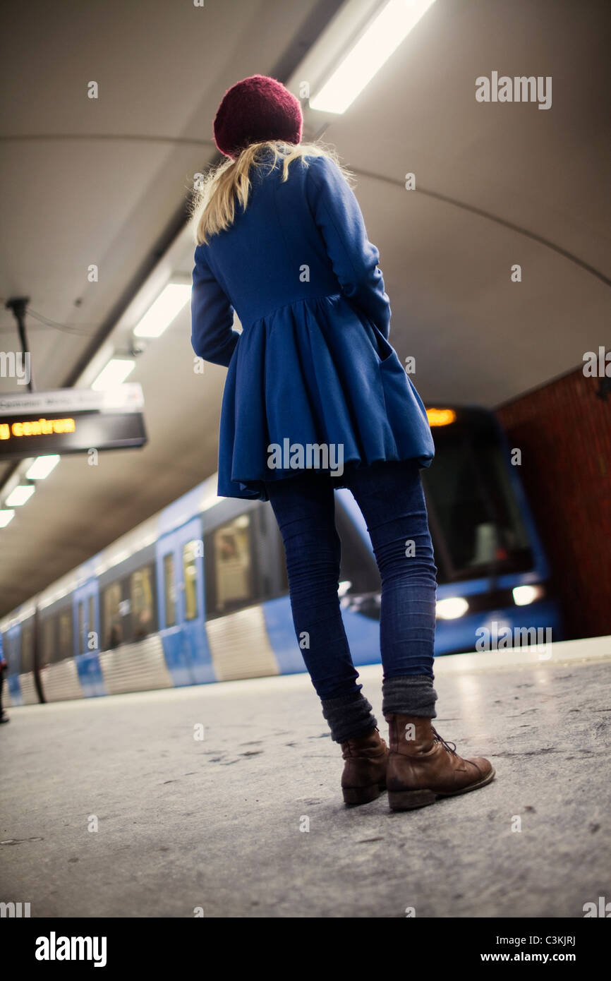 Teenage girl (14-15)standing on underground station platform Stock Photo