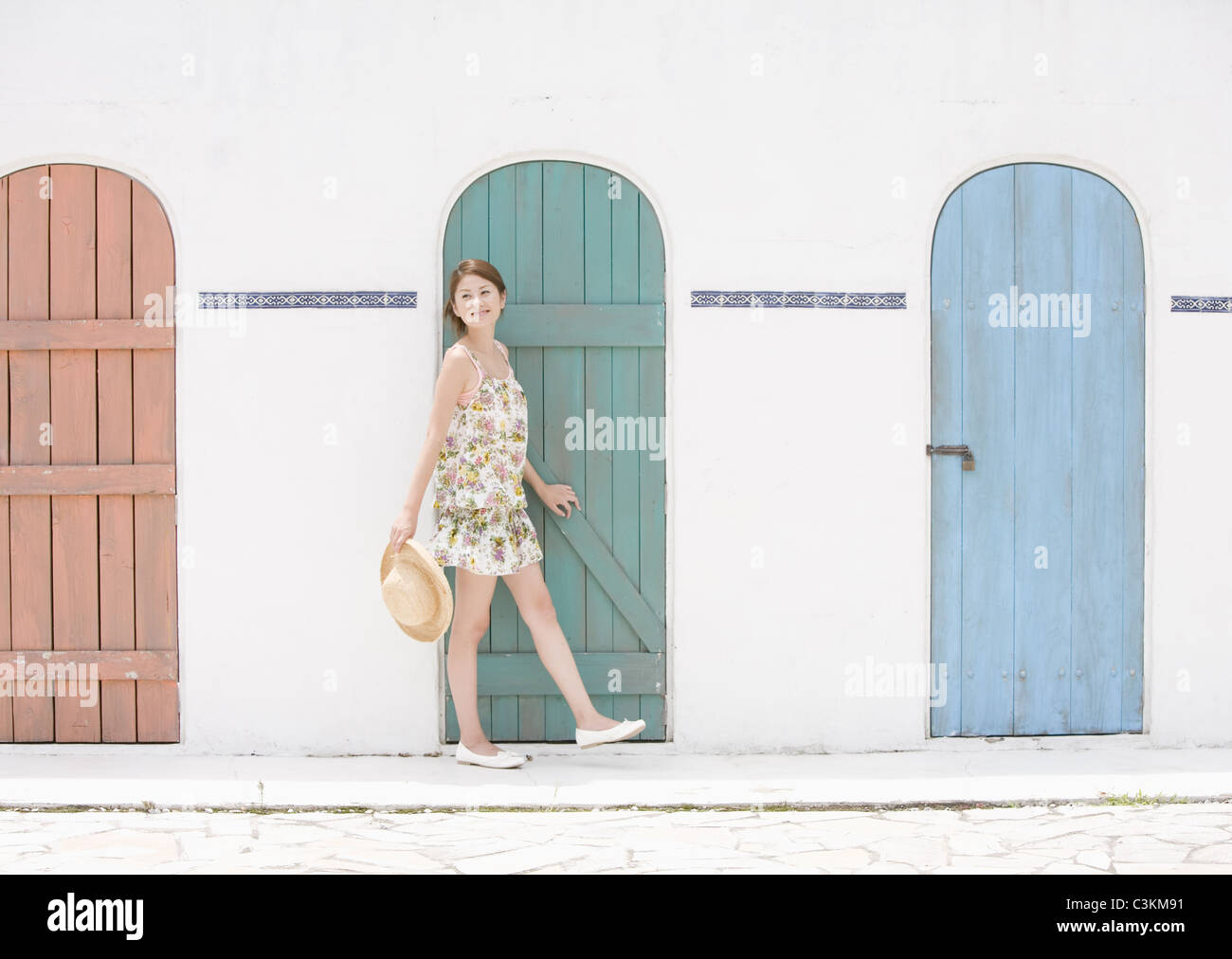 Young woman standing in front of doors Stock Photo - Alamy
