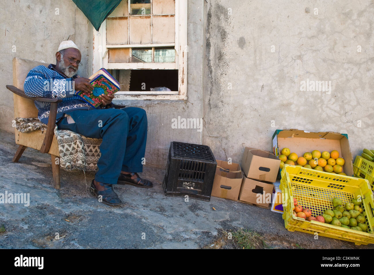 Man Reading The Koran And Selling Fruits Outside His House - 