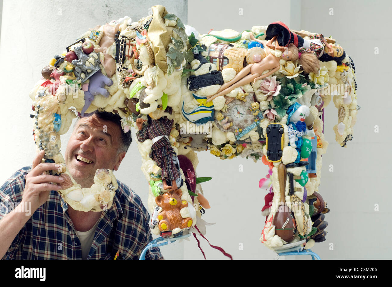 Sculptor Anthony Heywood lifts his sculpture 'Earth Elephant' made from recycled objects. Stock Photo