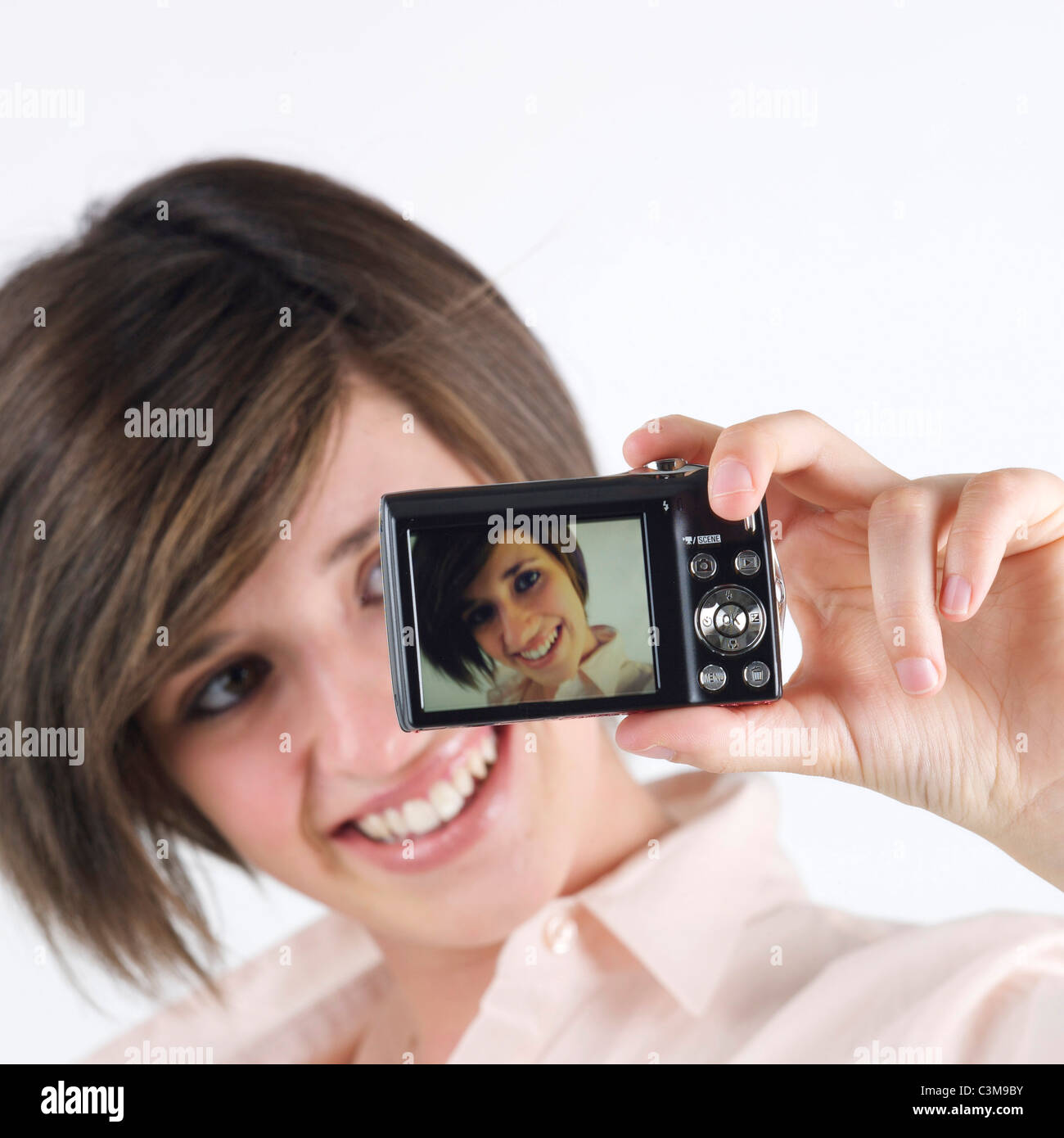 Young woman taking a photo of herself with a camera Stock Photo