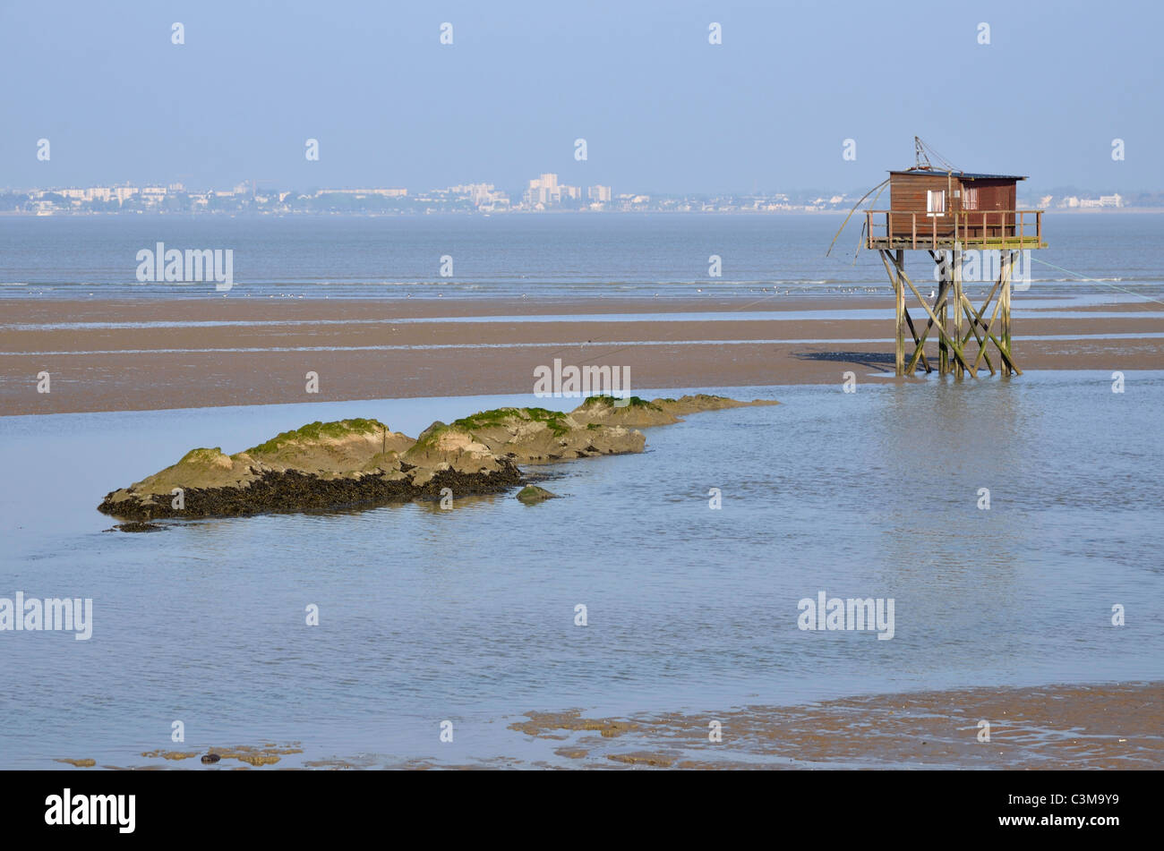 Fishing carrelet from Saint Brevin les Pins at low tide and the town of Saint Nazaire in the background in Pays de la Loire Stock Photo