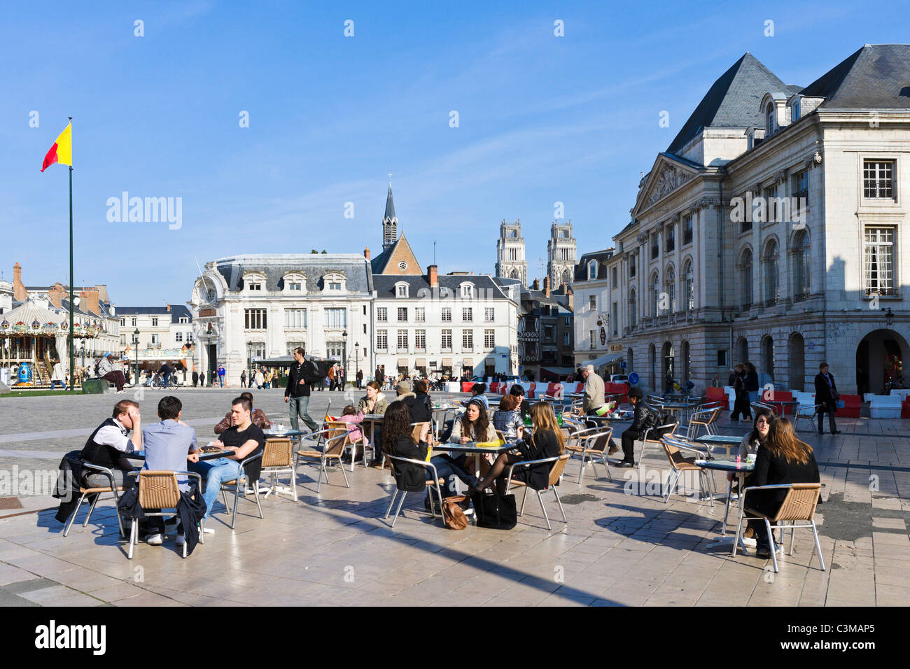 Pavement cafe in front of the statue of Joan of Arc with the cathedral towers in the distance, Place du Martroi, Orleans, France Stock Photo