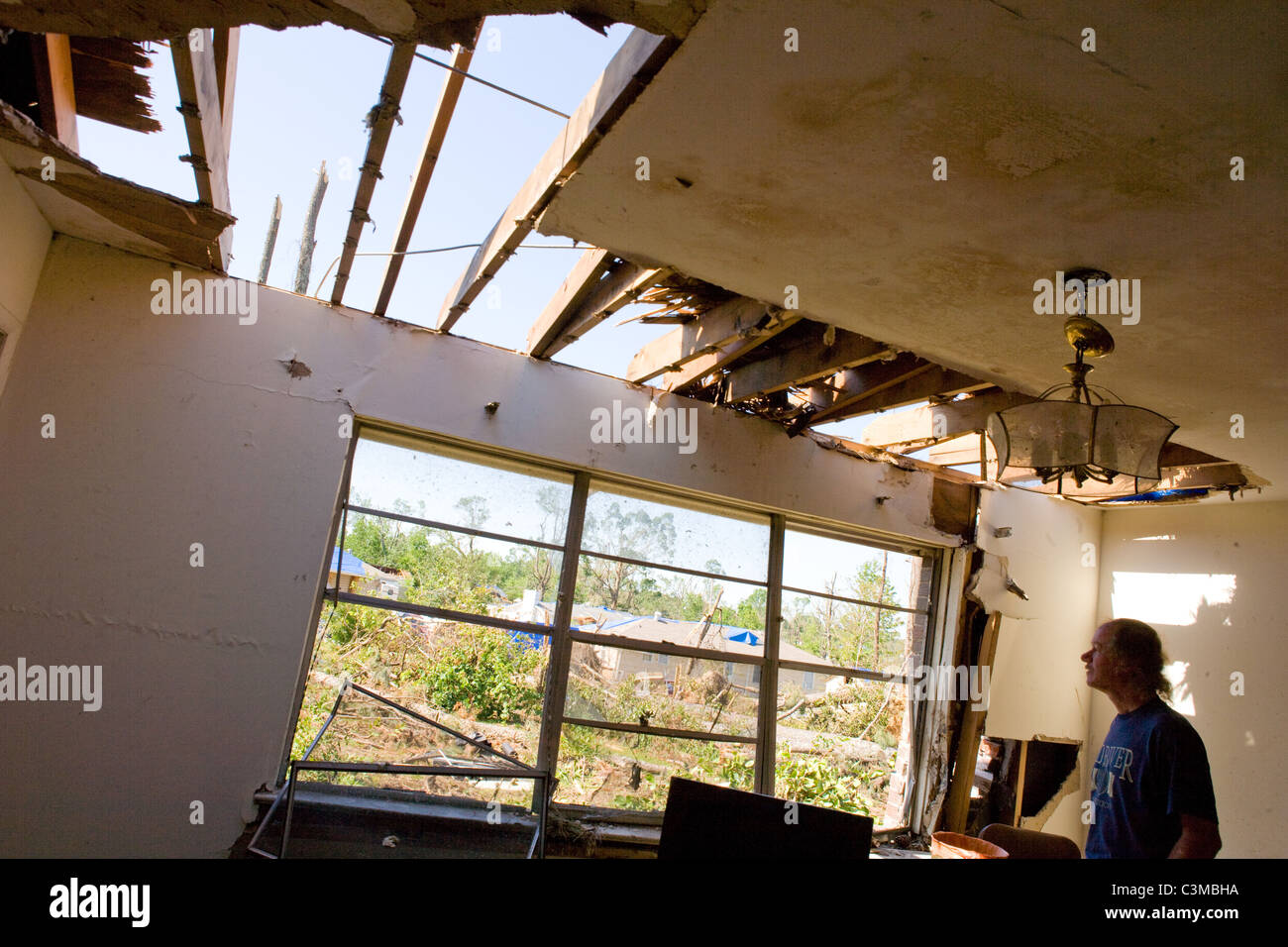 A man looks at damage to his home after tornado hits his town in Tuscaloosa Alabama, USA Stock Photo