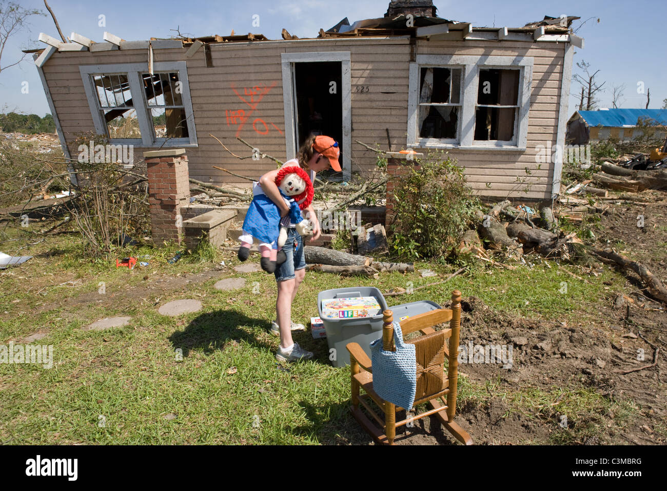 Woman carrying her children's belongings out of her destroyed home after tornado hits Pleasant Grove, Alabama, USA May 2011 Stock Photo
