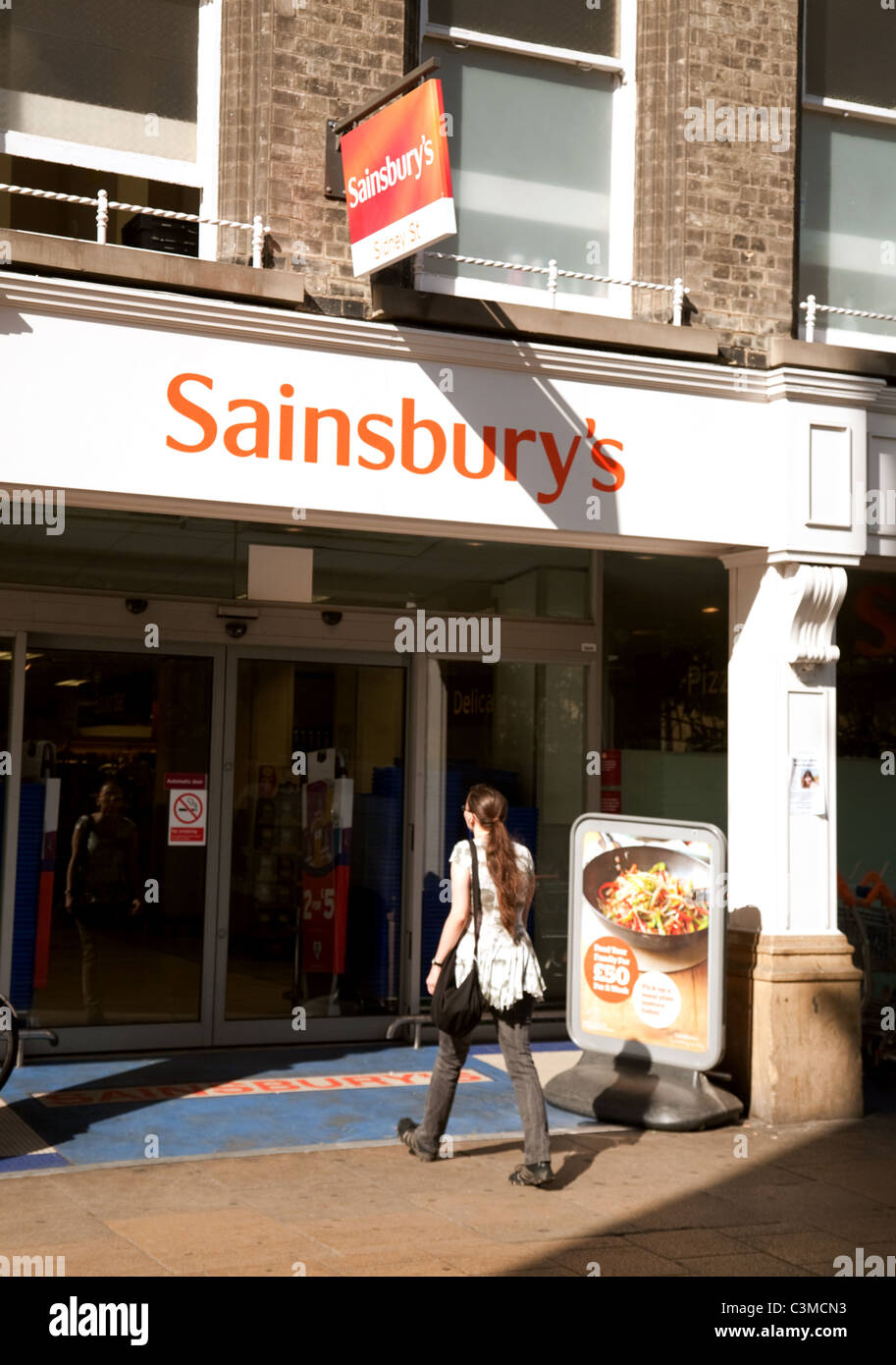 A woman entering Sainsburys supermarket, Sidney Street Cambridge UK Stock Photo