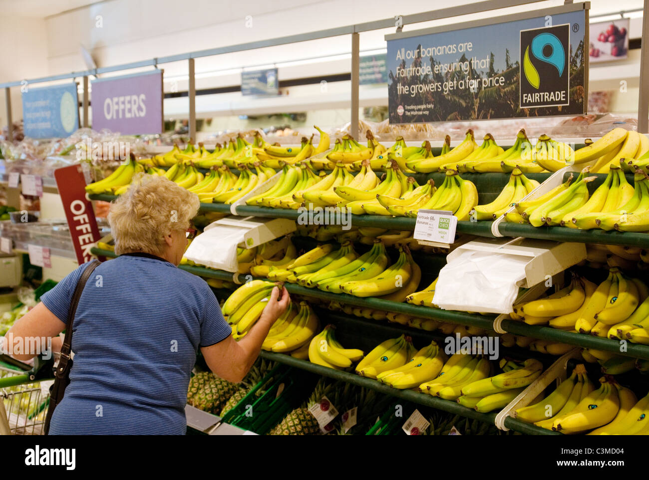 An elderly woman buying bananas in a supermarket, Waitrose, Newmarket