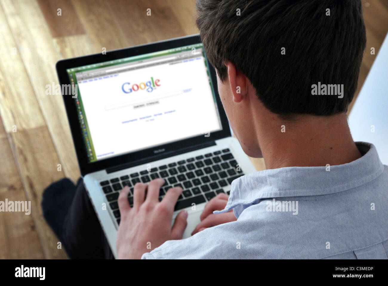 Young man using laptop on Google home page. Stock Photo