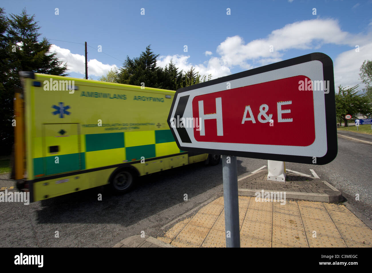Wales ambulance passes A&E Accident and Emergency sign at Ysbyty Glan Clwyd, Bodelwyddan, Welsh NHS, Betsi Cadwaladr Board. Stock Photo