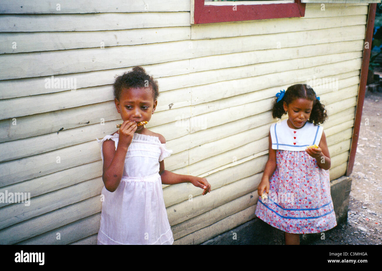 Dominican Republic Two Girls Eating By House On A Fruit Farm Stock