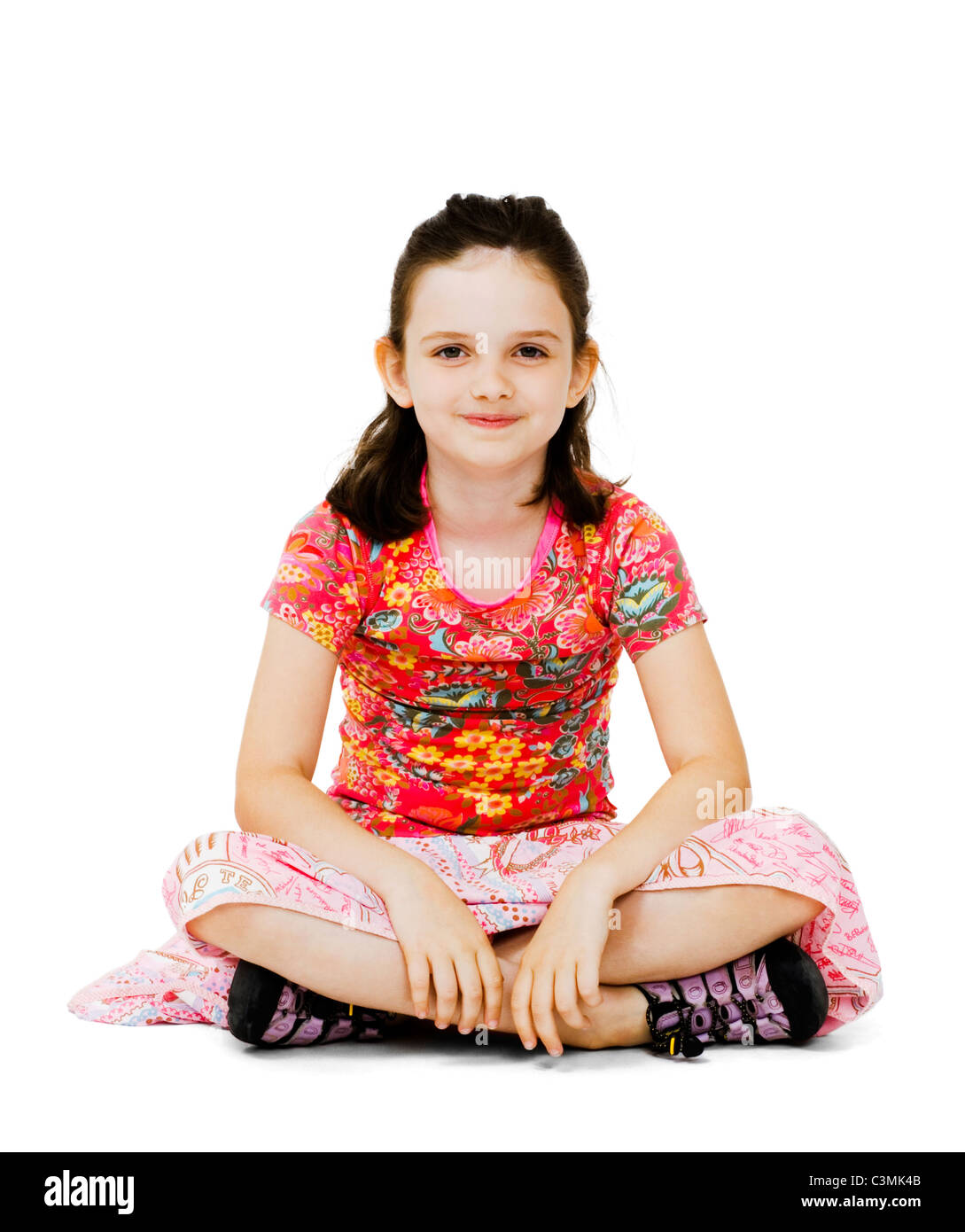 Smiling girl sitting on the floor isolated over white Stock Photo - Alamy