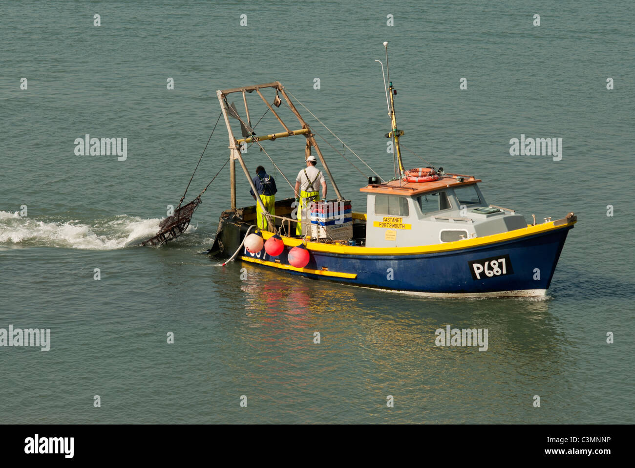 fishing boat trawler two fisherman Portsmouth Harbour UK Stock Photo