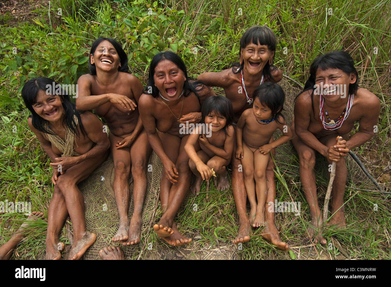 Huaorani Indians: Laughing women and children sitting in the forest. Bameno Community, Yasuni National Park, Ecuador. Stock Photo