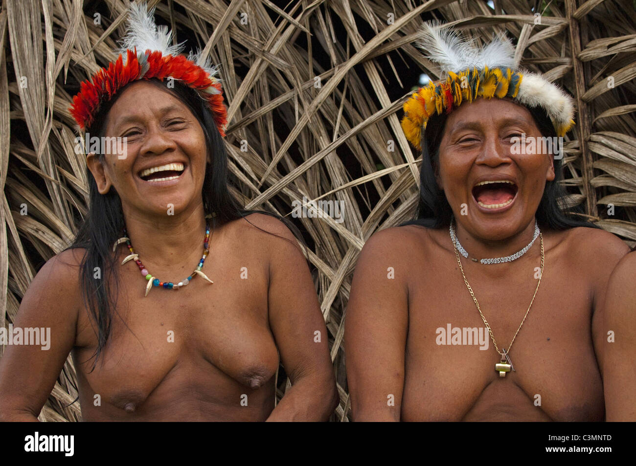 Huaorani Indians: Laughing women (Awame Gomoke and Dete Iteka). both wearing crowns topped with Harpy Eagle feathers Stock Photo