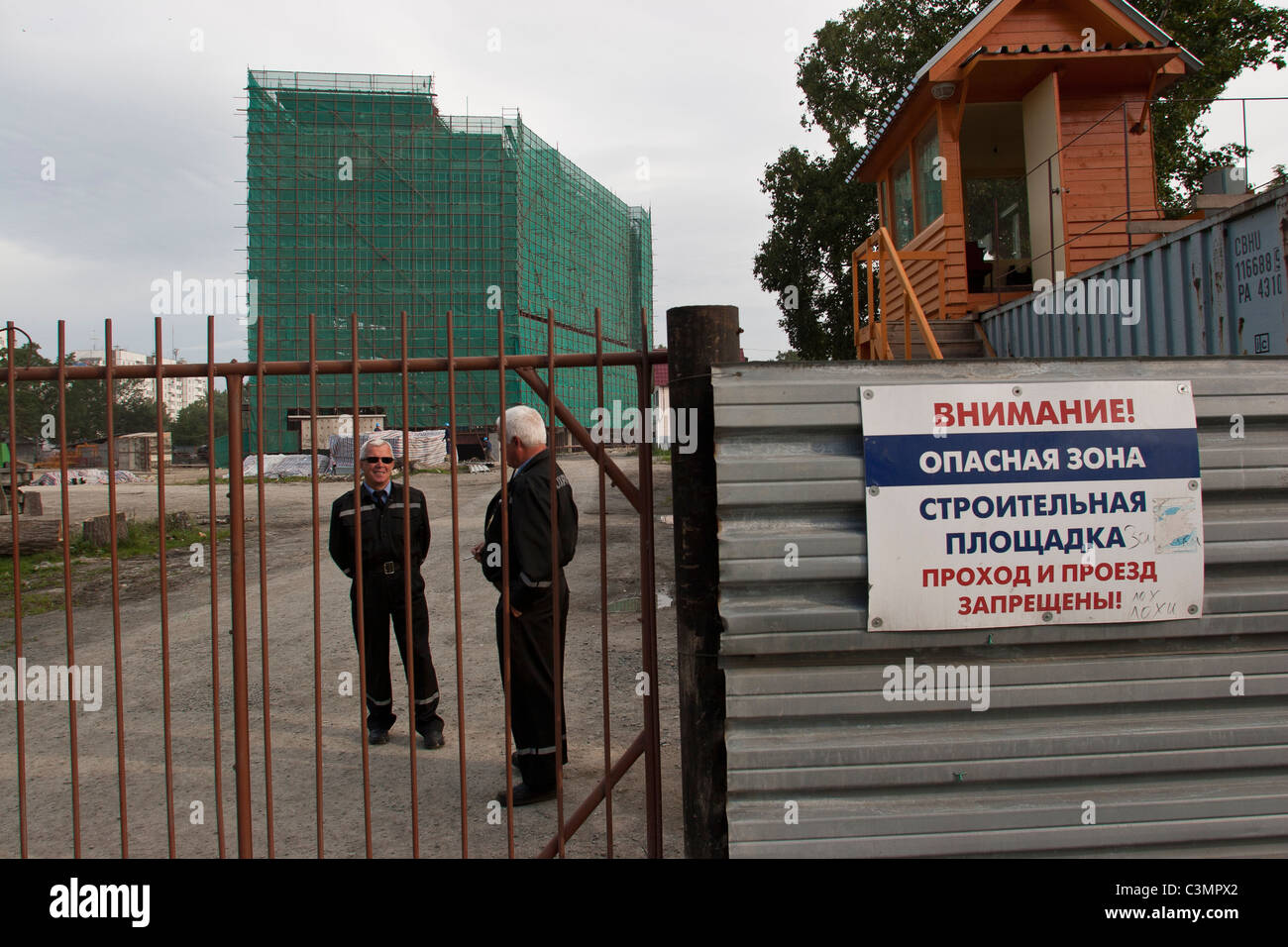 Security guards stand outside an office building under construction in
