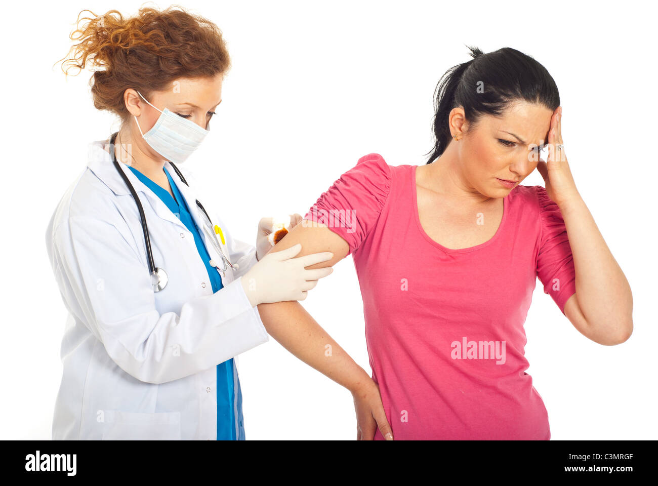 Doctor giving first aid and cleaning hurting woman with hand wound with