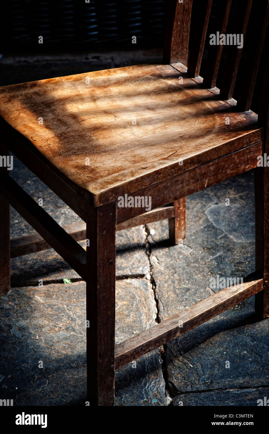 Old oak wooden kitchen chair on a welsh slate floor Stock Photo