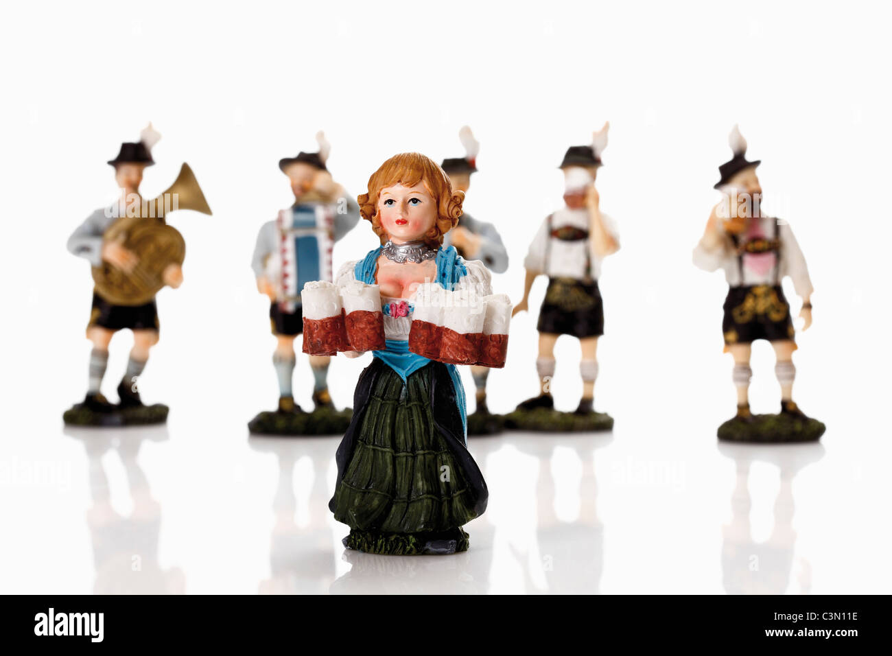 Bavarian waitress figurines holding beer stein with music band in background Stock Photo